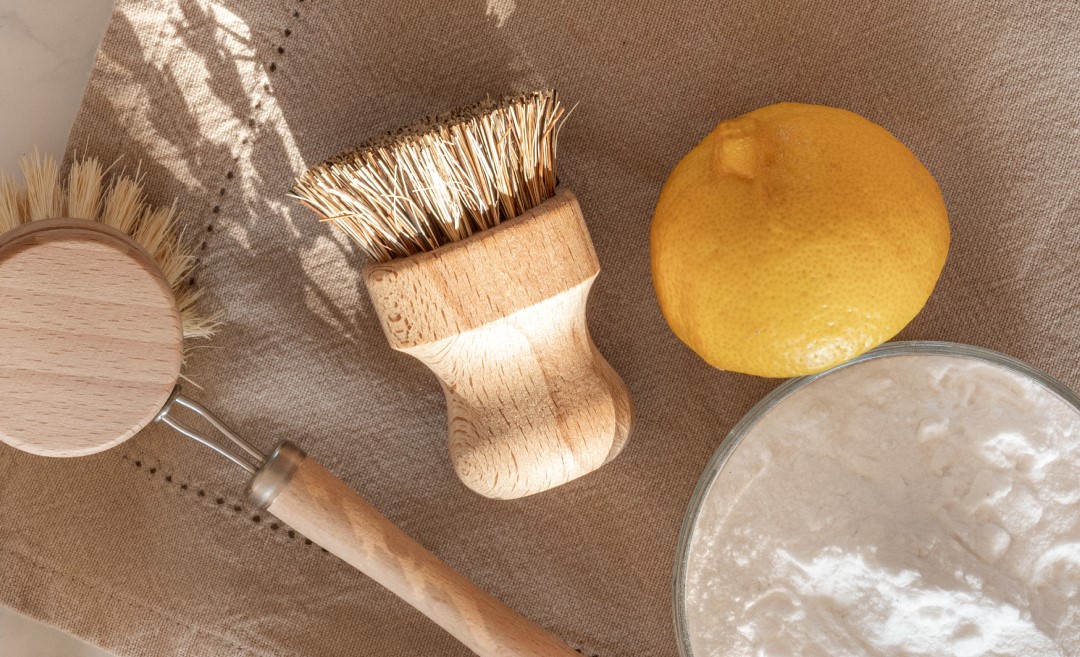 Scrub brush, lemon, and baking soda sitting on cloth - Young Living Lavender Life Blog 