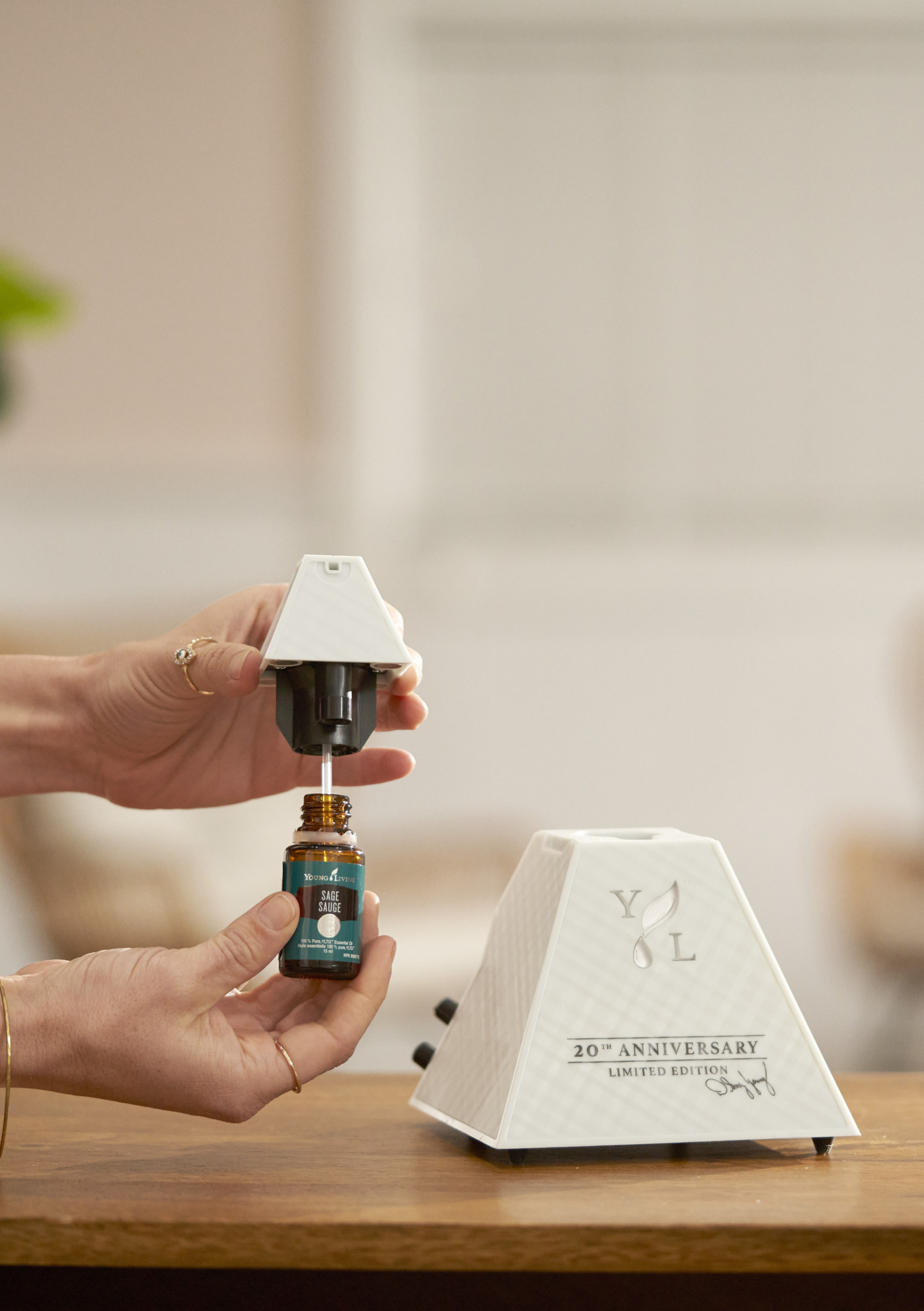 Person attaching essential oil bottle to AromaLux Atomizing Diffuser - Young Living Lavender Life Blog 