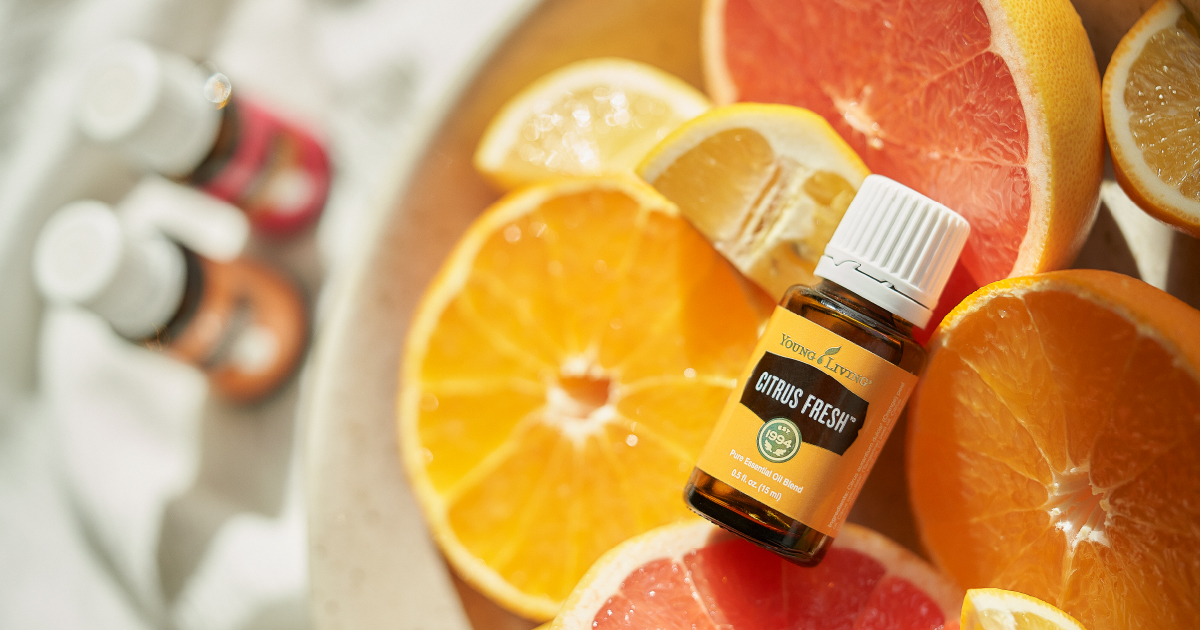 Citrus Fresh Essential Oil Blend sitting on top of fresh cut citrus fruit - Young Living Lavender Life Blog