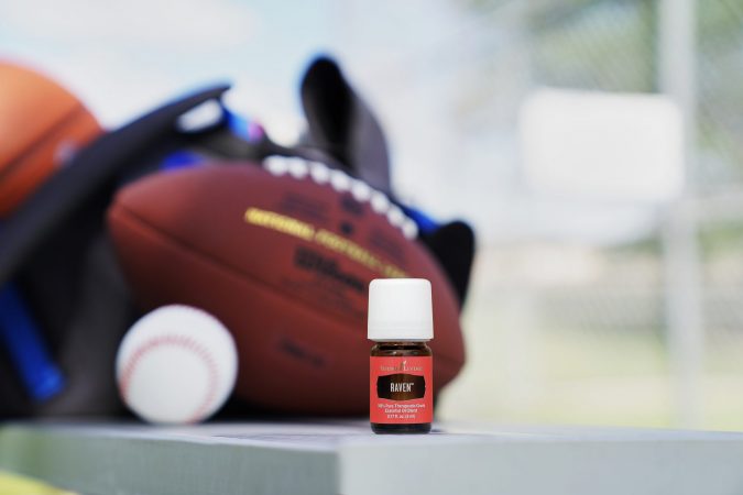 A bottle of raven essential oil with sports equipment, use raven essential oil after exercising or playing sports 